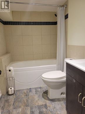 Markham (Unionville) apartment for rent - A white toilet sits next to a bathtub in a bathroom.