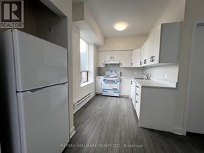 Toronto (Moss Park) apartment for rent - A kitchen with a white fridge and cabinets is shown.