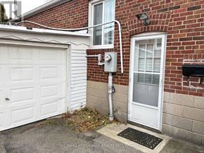 Toronto (Birchcliffe-Cliffside) apartment for rent - A white garage door is on the left of a brick building.