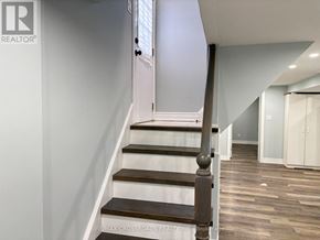 Toronto (Birchcliffe-Cliffside) apartment for rent - A staircase with a wooden handrail and steps leading to a door.
