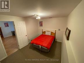 Kawartha Lakes (Bobcaygeon) apartment for rent - A bedroom with a red bed and a white door.