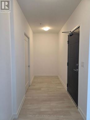 Hamilton (Corktown) condo for rent - A long hallway with a black door on the right.