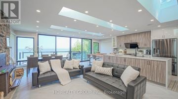 Tiny apartment for rent - A modern living room with a grey sofa set and a kitchen area with stainless steel appliances.