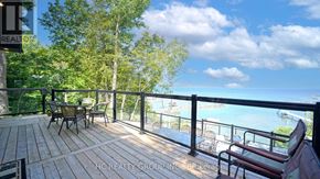 Tiny apartment for rent - A deck with chairs and a railing overlooking a body of water.