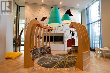 Toronto (Willowdale East) condo for rent - A modern living room with a wooden bookshelf and a giraffe statue.