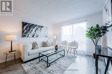 Toronto (Woburn) condo for rent - A living room with a white couch, a black coffee table, and a large abstract painting on the wall.