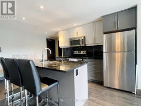 Waterloo condo for rent - A kitchen with a granite countertop and stainless steel appliances.