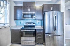 Hamilton (Stoney Creek Mountain) townhouse for rent - A kitchen with a stainless steel refrigerator, oven, and microwave.