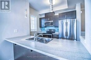Hamilton (Stoney Creek Mountain) townhouse for rent - A modern kitchen with stainless steel appliances and a large island.
