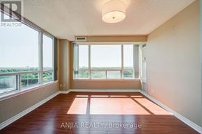 Toronto (Bayview Village) condo for rent - A room with a large window and wooden flooring.