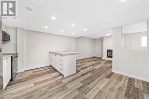 Prince Edward County (Wellington Ward) apartment for rent - A spacious kitchen with white cabinets and a wooden floor.