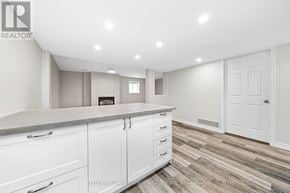 Prince Edward County (Wellington Ward) apartment for rent - A kitchen with white cabinets and a wooden floor.