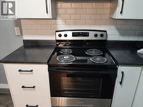 Windsor apartment for rent - A modern kitchen with a black countertop and a stove with four burners.