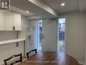 Bradford West Gwillimbury (Bradford) apartment for rent - A kitchen with white cabinets and a wooden table.