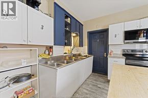 Windsor apartment for rent - A kitchen with white cabinets and a blue door.