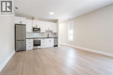 Hamilton apartment for rent - A kitchen with white cabinets and a wooden floor.