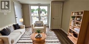 Waterloo townhouse for rent - A living room with a white couch, a wooden coffee table, and a bookshelf.