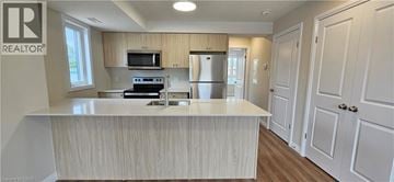 Waterloo townhouse for rent - A kitchen with a white counter top and wooden cabinets.