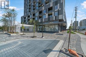 Vaughan (Concord) condo for rent - A modern building with a glass facade and a brick walkway in front.