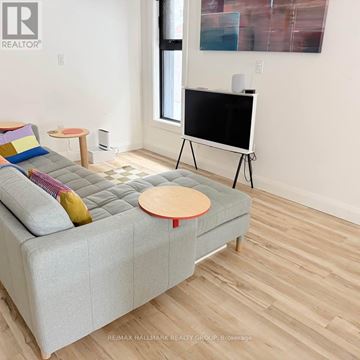 Ottawa multi-family for rent - A living room with a grey couch and a flat screen TV.