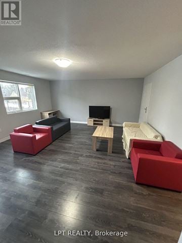 Waterloo townhouse for rent - A living room with a red couch and a wooden table.