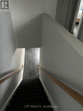 Waterloo townhouse for rent - A staircase with a wooden handrail and black steps.