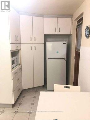 Toronto (Kensington-Chinatown) apartment for rent - A kitchen with white cabinets and a fridge.