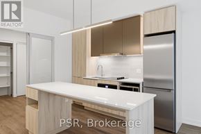 Toronto (Niagara) condo for rent - A modern kitchen with a white island and stainless steel appliances.