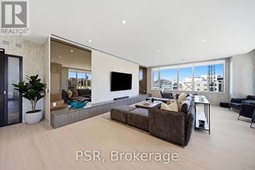 Toronto (Niagara) condo for rent - A modern living room with a large couch and a flat screen TV.