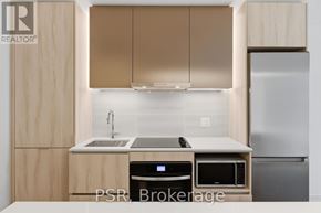 Toronto (Niagara) condo for rent - A kitchen with wooden cabinets and a stainless steel refrigerator.