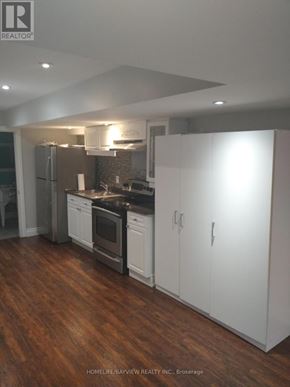 Bradford West Gwillimbury (Bradford) apartment for rent - A kitchen with white cabinets and a black countertop.