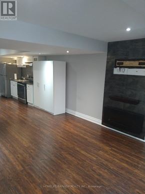 Bradford West Gwillimbury (Bradford) apartment for rent - A kitchen with white appliances and a wooden floor.