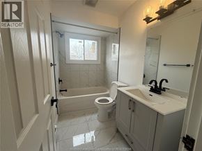 Windsor apartment for rent - A bathroom with a toilet, sink, and shower.