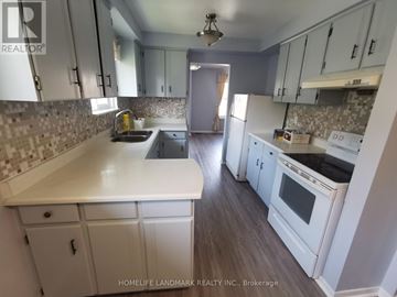 Toronto (Tam O'shanter-Sullivan) apartment for rent - A kitchen with white cabinets and a tiled backsplash.