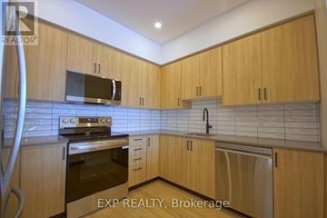 Ottawa triplex for rent - A kitchen with wooden cabinets and a stainless steel oven.