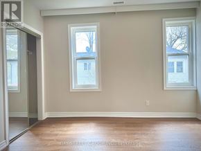 Hamilton (Hamilton Beach) apartment for rent - A room with two windows and a door leading to another room.