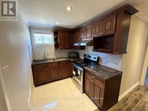 Toronto (Pleasant View) apartment for rent - A kitchen with brown cabinets and a black stove top oven.