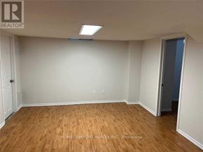 Markham (Cedarwood) apartment for rent - A room with wooden flooring and white walls, with a door on the right side.
