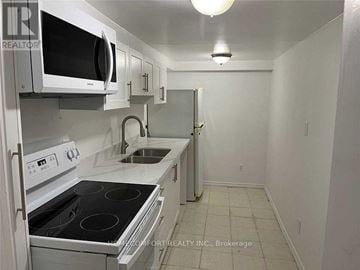 Markham (Cedarwood) apartment for rent - A white kitchen with a stove, microwave, and oven.