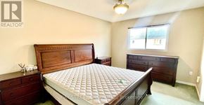 Markham (Berczy) apartment for rent - A bedroom with a large bed, a dresser, and a window.