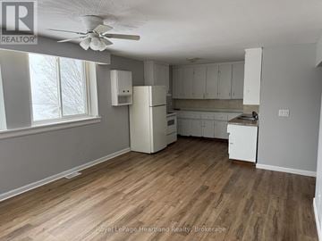Minto multi-family for rent - A kitchen with white cabinets and a wooden floor.
