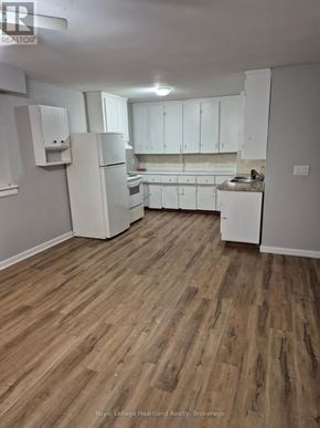 Minto multi-family for rent - A kitchen with white appliances and wooden floors.