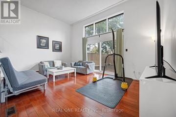 Toronto (Hillcrest Village) townhouse for rent - A living room with a grey chair and a white sofa.