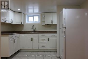 Richmond Hill (Crosby) apartment for rent - A kitchen with white cabinets and a refrigerator.