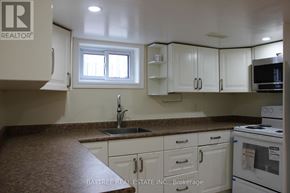 Richmond Hill (Crosby) apartment for rent - A kitchen with white cabinets and a brown countertop.
