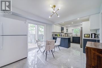 Toronto (West Hill) apartment for rent - A kitchen with a white fridge and a table with chairs.