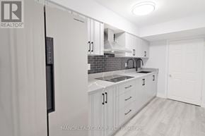 Ajax (Central East) apartment for rent - A kitchen with white cabinets and a black refrigerator.
