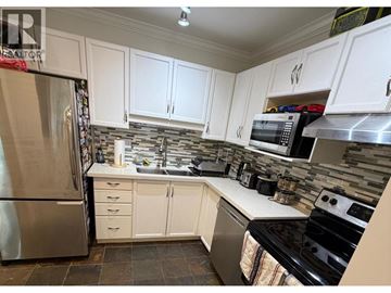 Port Coquitlam apartment for rent - A kitchen with white cabinets and a stainless steel refrigerator.