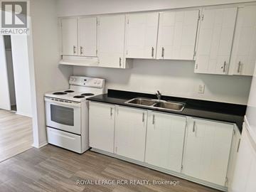 Aurora (Hills Of St Andrew) multi-family for rent - A kitchen with white cabinets and a stove top oven.