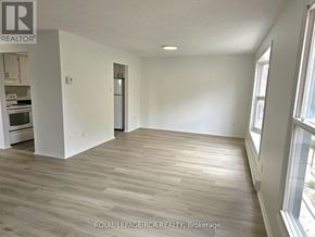 Aurora (Hills Of St Andrew) multi-family for rent - A spacious room with wooden flooring and white walls.